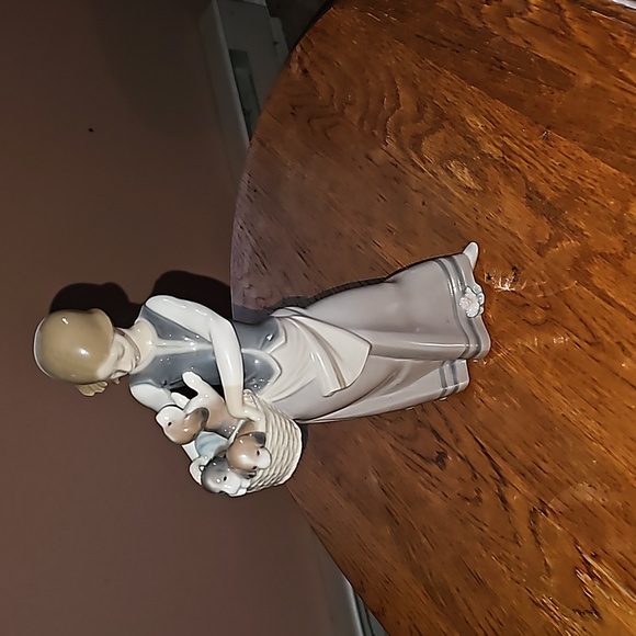 Women holding basket ofpuppies lladro